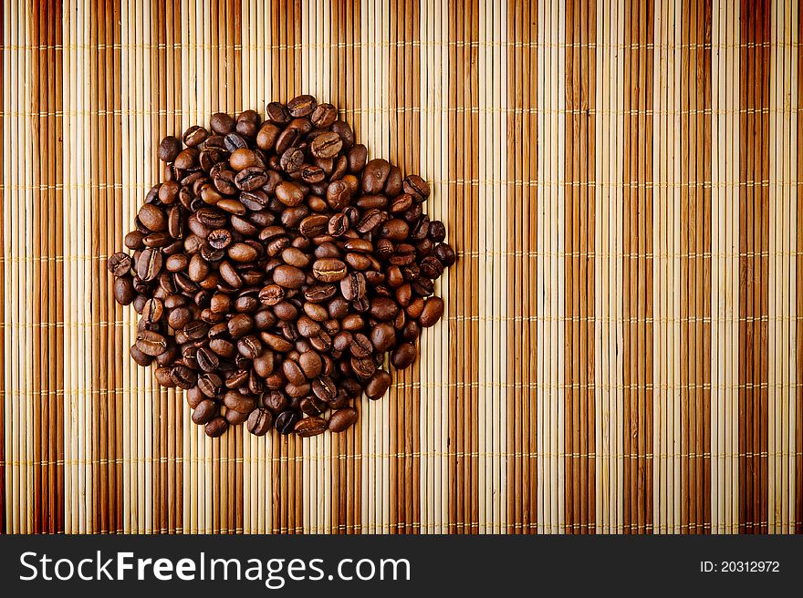 Handful aromatic coffee beans on brown background