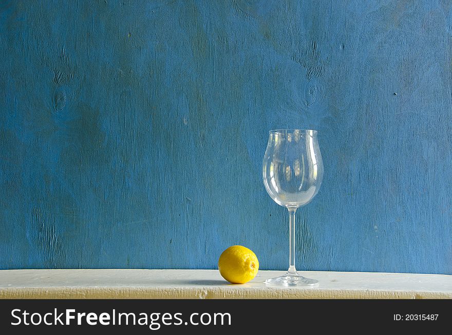 Still-life with yellow lemon and empty wineglass