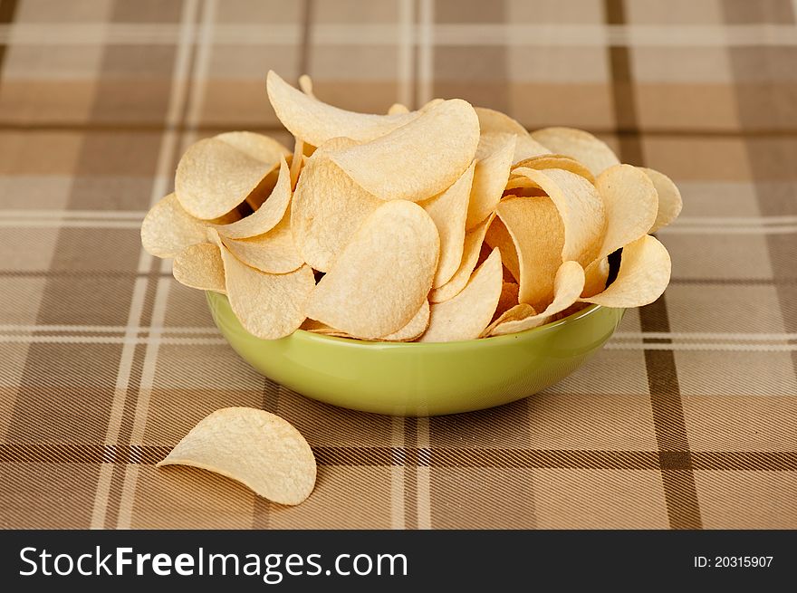 Delicious potato chips in green bowl