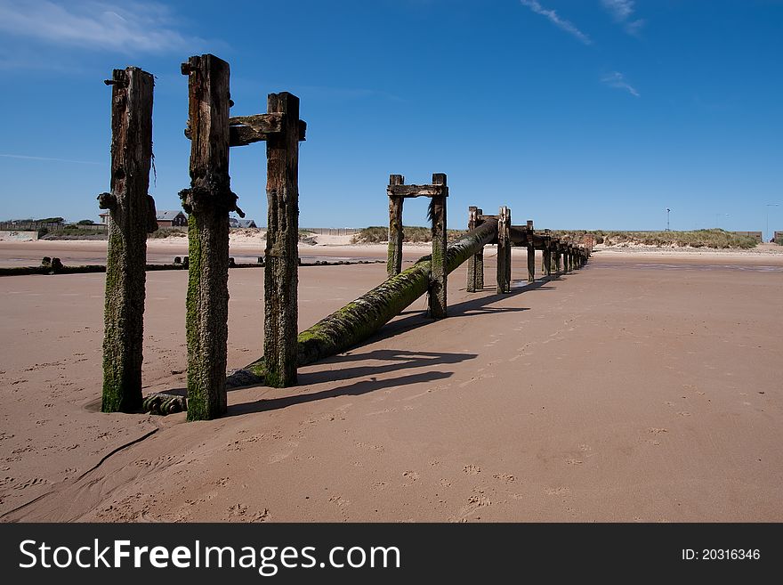 Sewage outlet pipe running along a beach