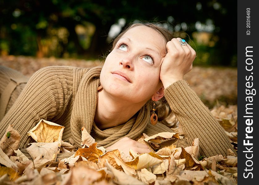 Young beauty lying in autumn leaves. Young beauty lying in autumn leaves