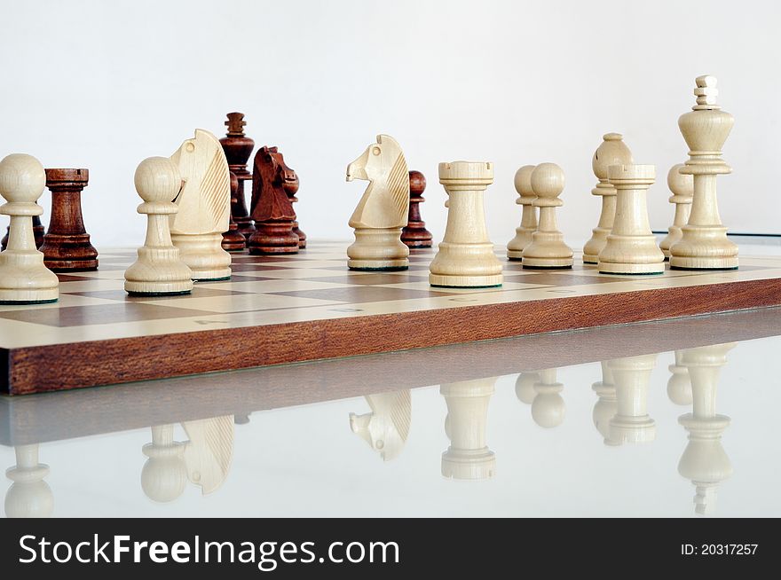 Chess pieces on wood board, black and white