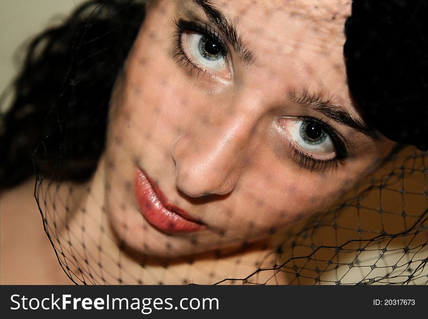 Black haired girl, old fashioned hat tilted forward, with the netting covering her face. Black haired girl, old fashioned hat tilted forward, with the netting covering her face.