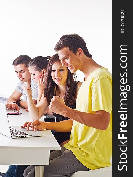 Young couple in front of laptop with others in the background. Candid picture. Young couple in front of laptop with others in the background. Candid picture.