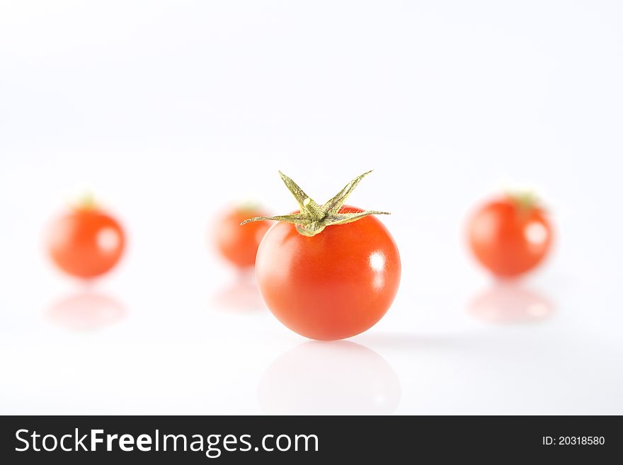 Photography of a tomato in front of 3 tomatos. Photography of a tomato in front of 3 tomatos.