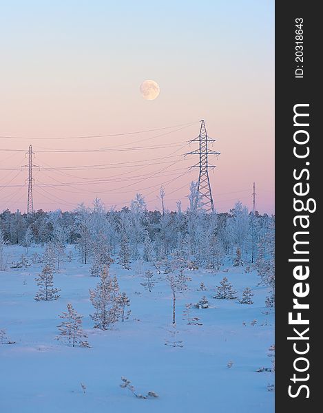 The moon on a winter evening over a power line. The moon on a winter evening over a power line