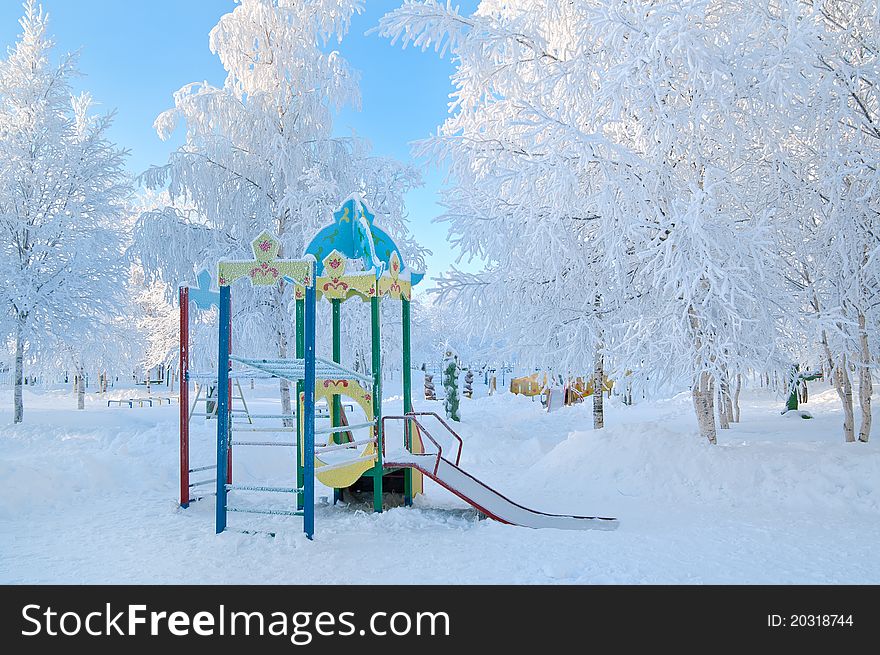 Playground in a kindergarten in the winter. Trees in a rich frost frosty day