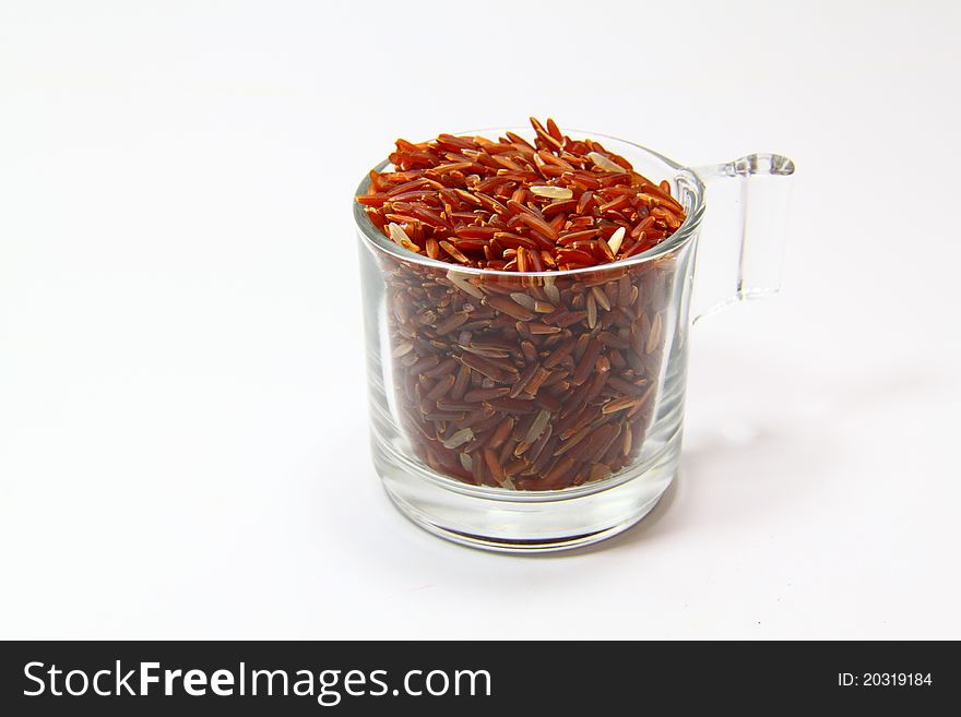 Red jasmine rice and beaker on a white background