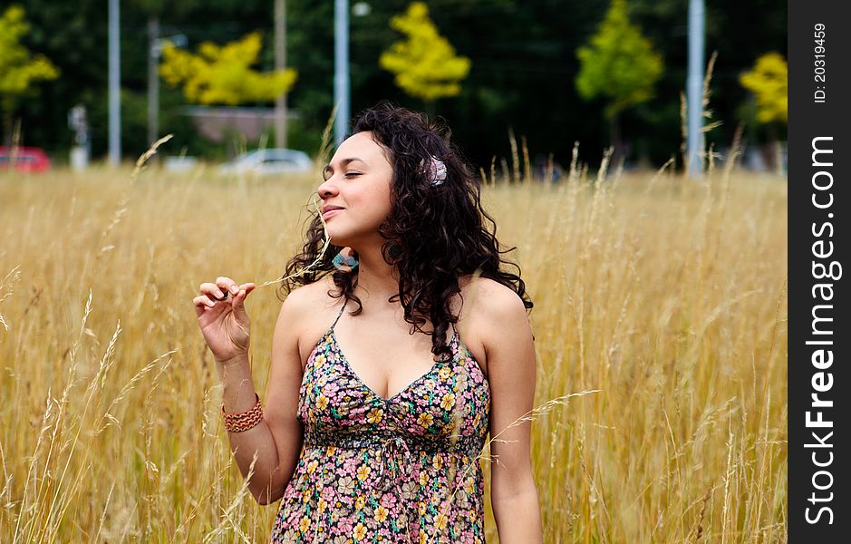 Woman standing in a field and touching her face with spica. Woman standing in a field and touching her face with spica