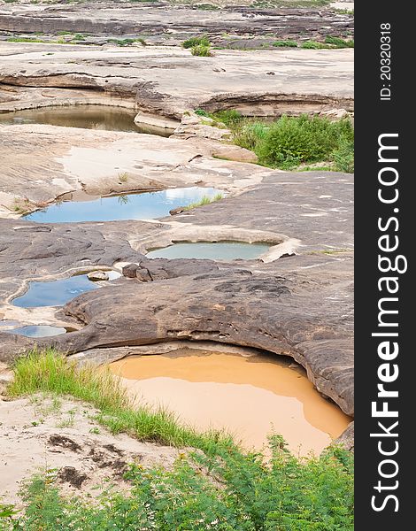 Two color water in the hole of rock in Khong River after the water come down