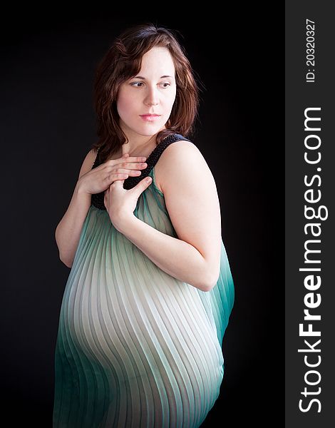 Happy pregnant young woman in black lingerie.