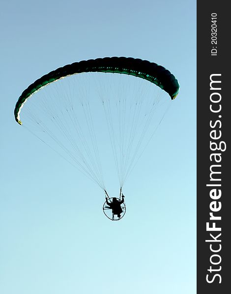 Flight with motor paragliding, light blue sky
