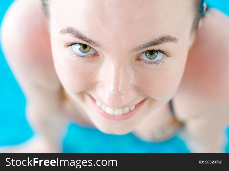Close-up portrait of a smiling girl in a swimming pool with copy space. Close-up portrait of a smiling girl in a swimming pool with copy space