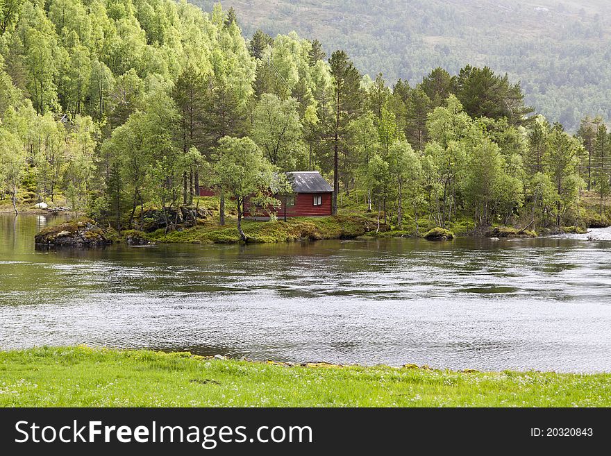 Norway scenery with pine forest, river and fishman’s house