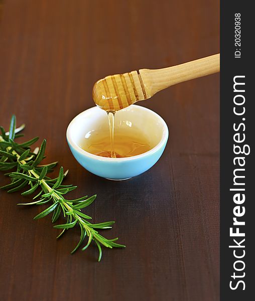 Fresh golden honey running from wooden drizzler on dark wooden background. Fresh golden honey running from wooden drizzler on dark wooden background