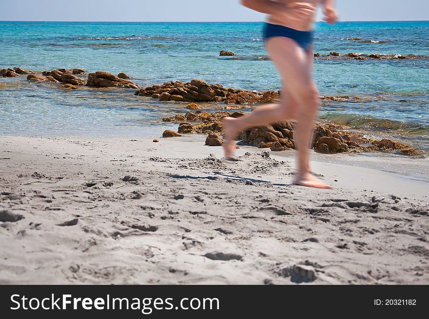 Man running on the beach in summer
