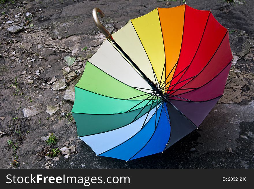 Very bright rainbow umbrella on the ground. Very bright rainbow umbrella on the ground