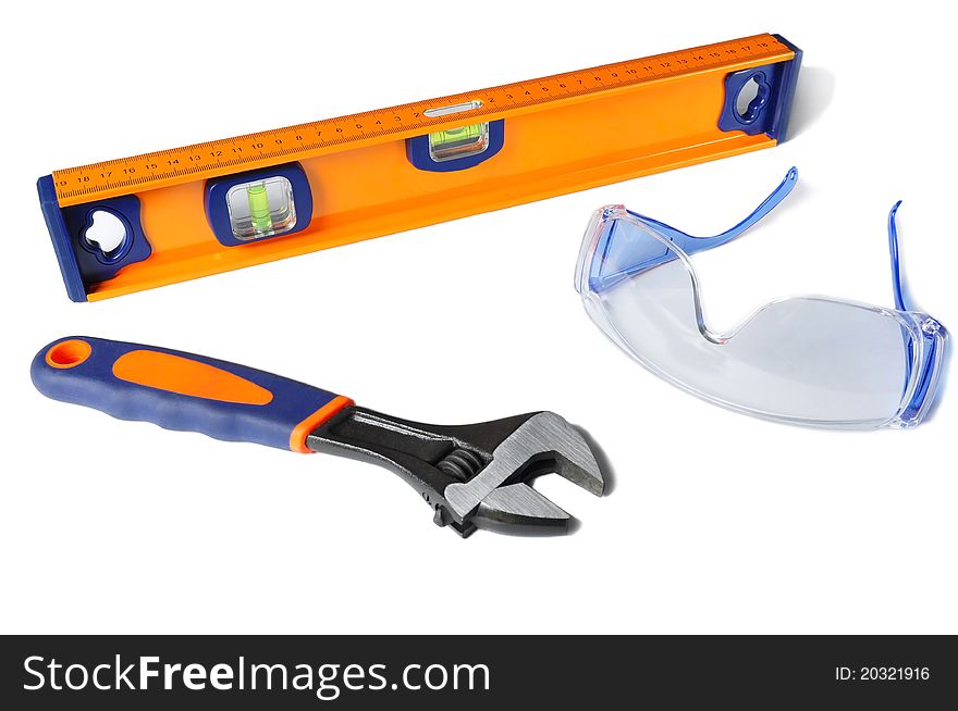 Safety glasses, a wrench and a ruller isolated on a white background. Safety glasses, a wrench and a ruller isolated on a white background