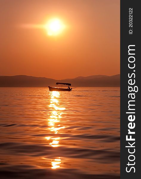 Fishermen Crossing A Lake At Sunset