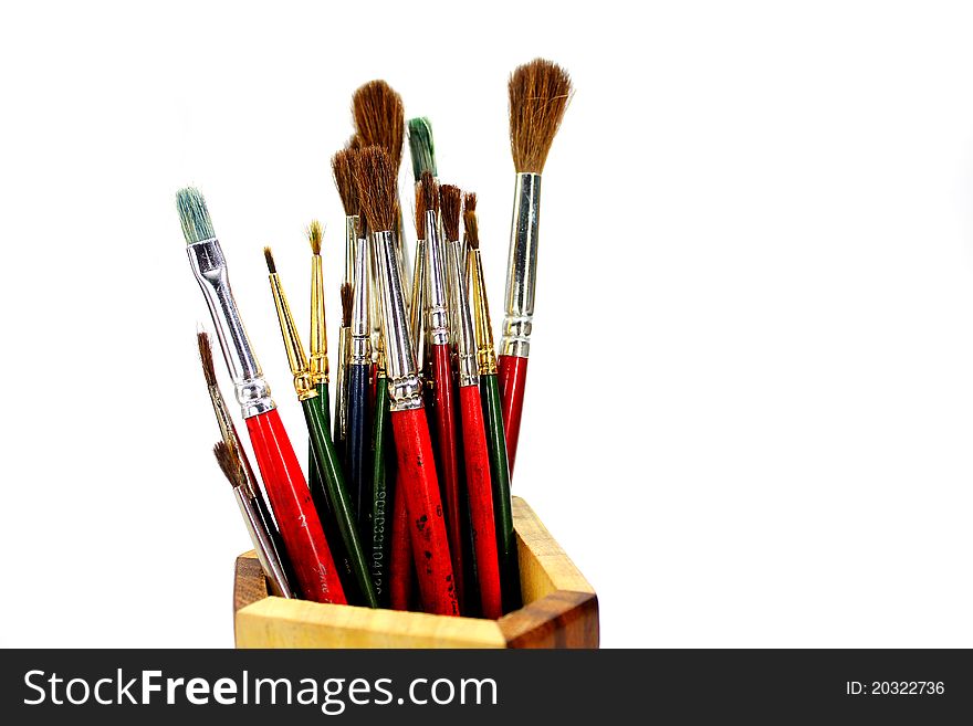 Paint brushes in wooden stand isolated white background