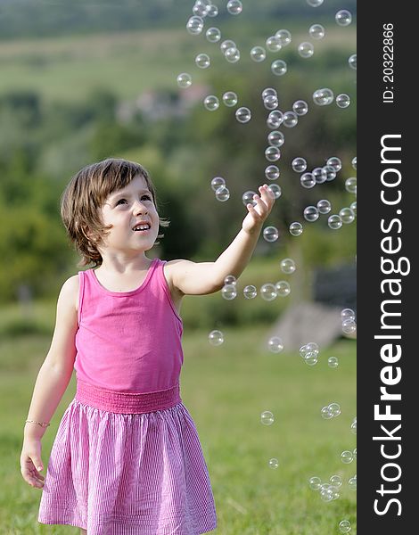 Little girl playing with balloons in nature in summer season. Little girl playing with balloons in nature in summer season