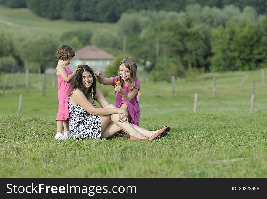 White adolescent girl and pretty child working with flowers and mother relaxing. White adolescent girl and pretty child working with flowers and mother relaxing