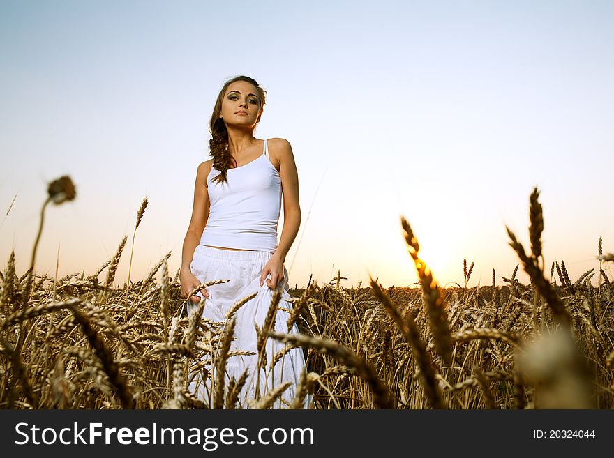 Woman in wheat field under blue sky