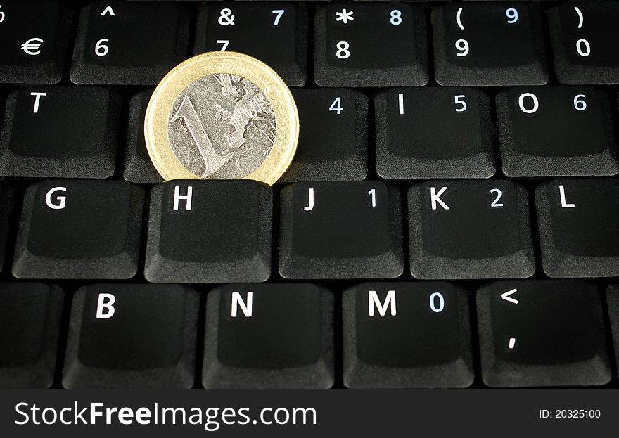 Euro coin on laptop keyboard