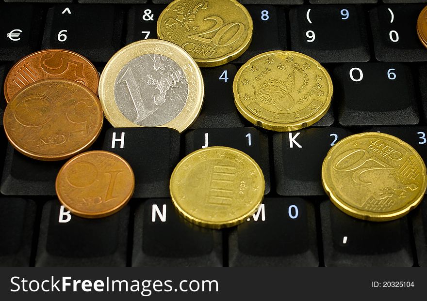 Euro coins on laptop keyboard