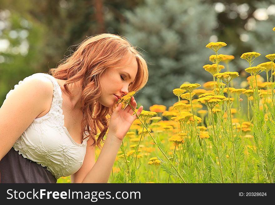 Pretty girl outdoors smells a flower. Pretty girl outdoors smells a flower