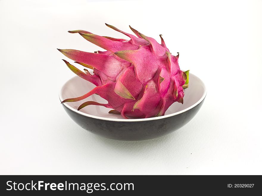 Red organic dragon fruit in cup on white background