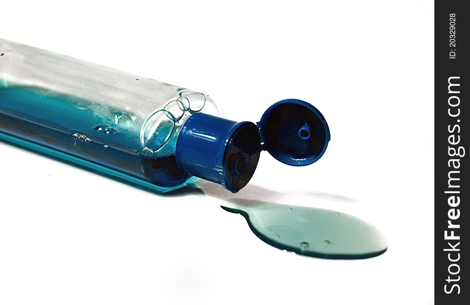 Bottle of blue liquid spilled away, isolated