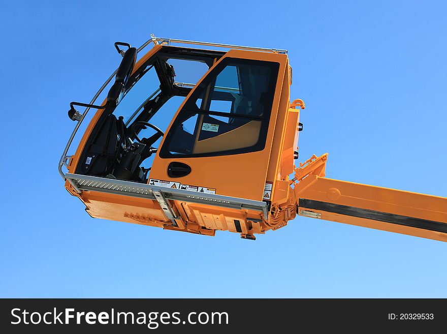 Operated cabin of the elevating crane against the sky. Operated cabin of the elevating crane against the sky