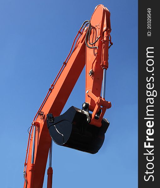 Excavator bucket against the blue sky