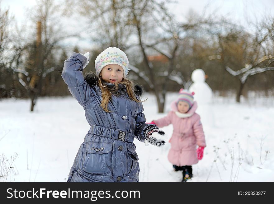 Two Little Girls Playing Snowballs