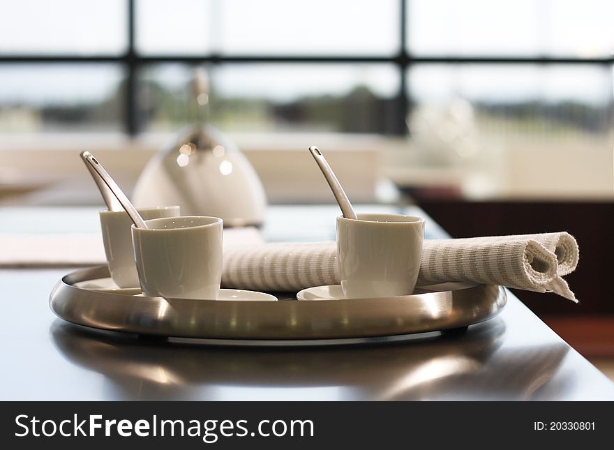 White ceramic cups of coffee and nupkin on tray. White ceramic cups of coffee and nupkin on tray.