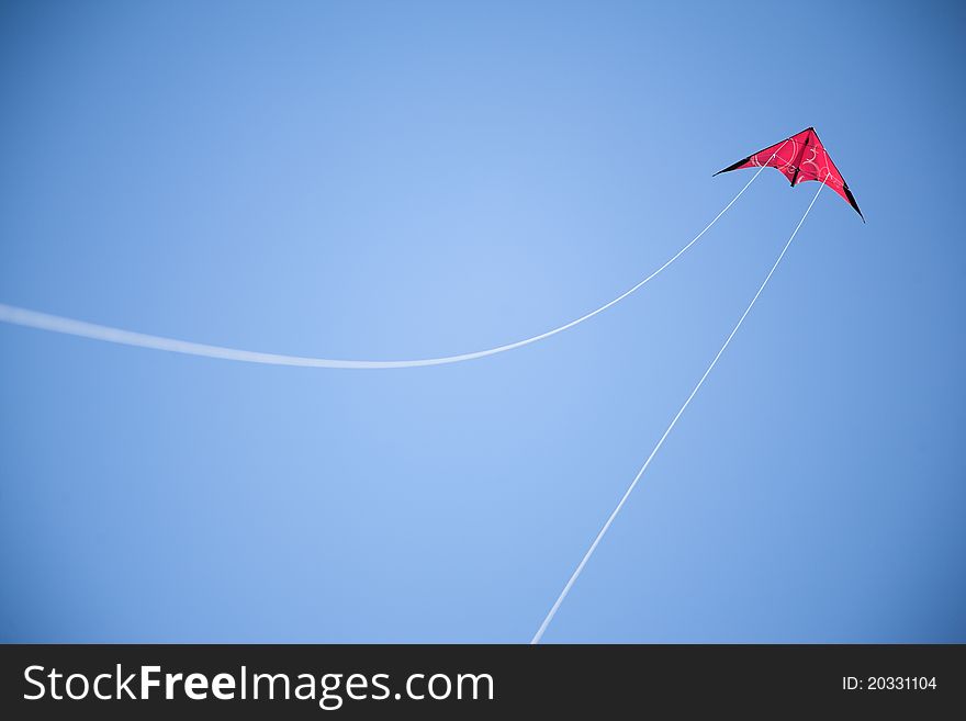 Red kite flies on blue sky, white strings. Red kite flies on blue sky, white strings