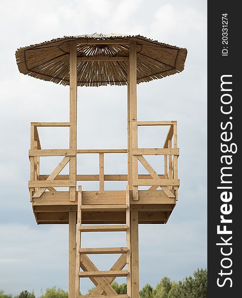Water rescuer's wooden tower, cloudy sky. Water rescuer's wooden tower, cloudy sky