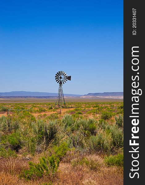 A scene in the western United States (Nevada), with an old-fashioned windmill, desert landscape and a bright blue sky. Lots of copy space. A scene in the western United States (Nevada), with an old-fashioned windmill, desert landscape and a bright blue sky. Lots of copy space.