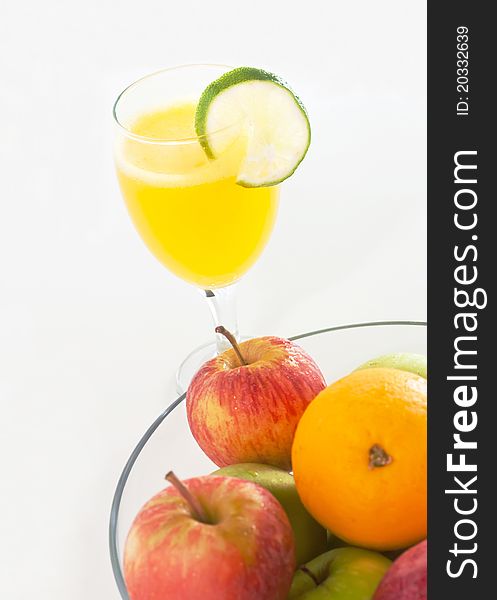 Orange juice and a bowl of apples