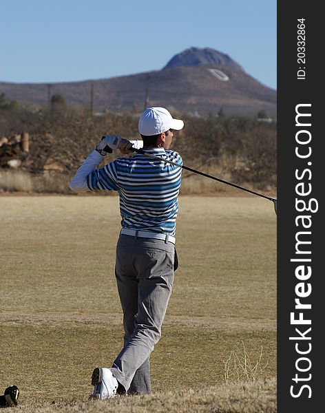 Man just finnishing a golf swing on the golf course. Man just finnishing a golf swing on the golf course