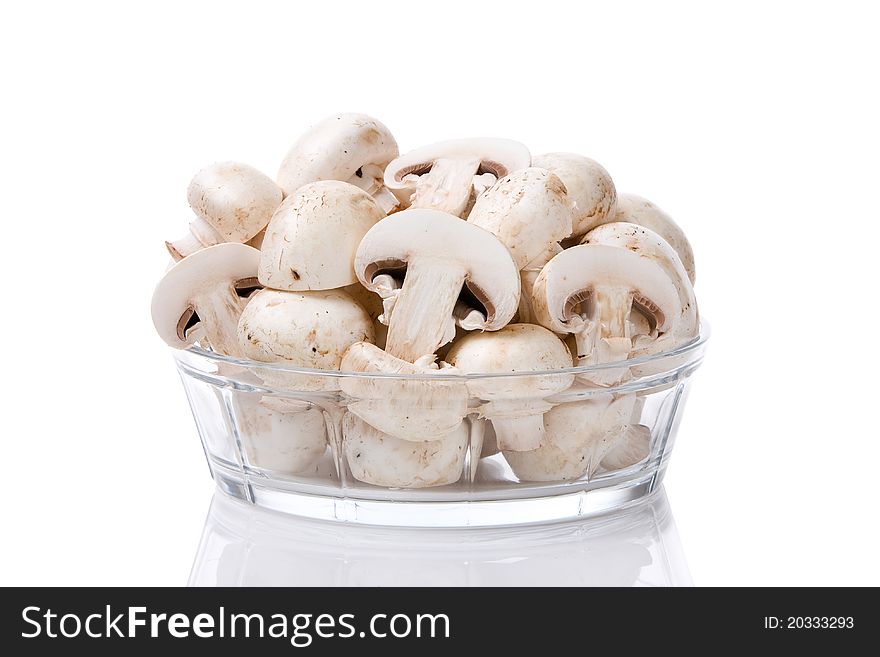 Bunch of sliced mushrooms in a glass bowl isolated on white background