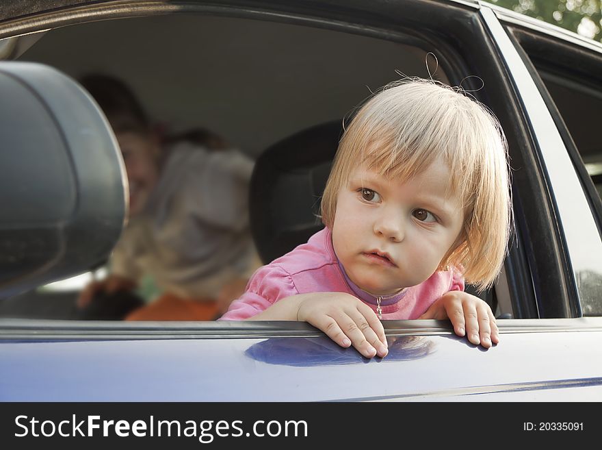 The child is put out from a car window. The child is put out from a car window