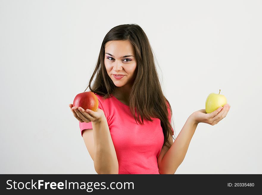 A pretty woman holding two colorful ripe apples - isolated on white