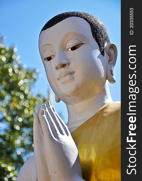 Buddist Monk statue with blue sky at Pra Sing Temple in Chiang Rai, Thailand