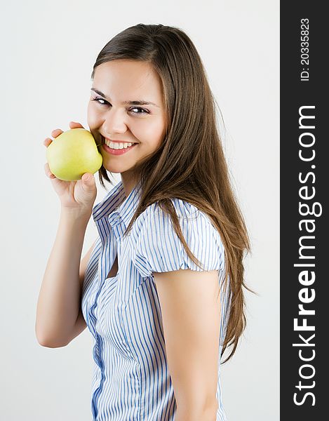 Beautiful young woman biting a green apple