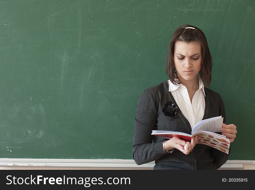 Dark-haired female student reads a notes of the board.