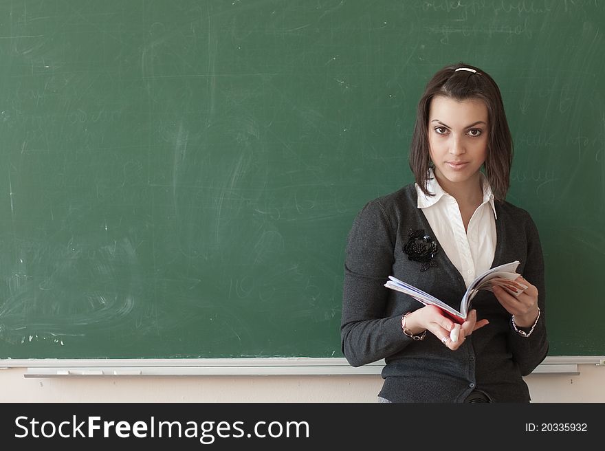 Dark-haired female student reads a notes of the board.