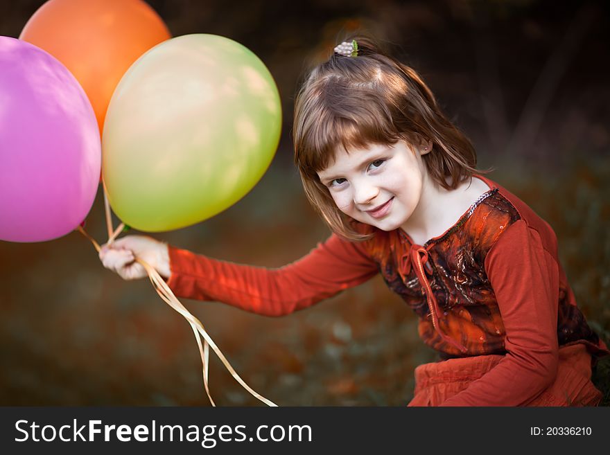 Red haired girl play with colourful baloons, in the autumn. Red haired girl play with colourful baloons, in the autumn