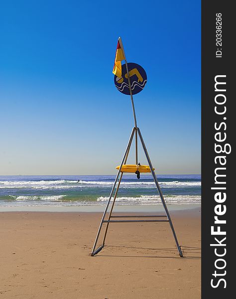 Sign indicating safe swimming zone on a deserted beach in Durban, South Africa, with golden sand blue sea and cloudless sky